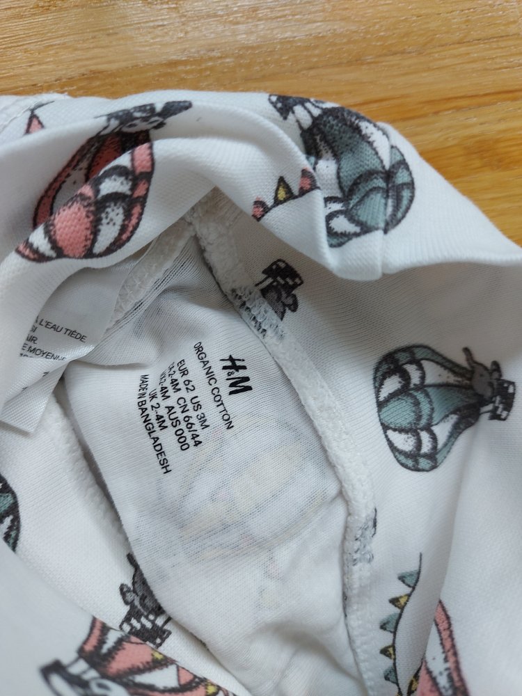 Weiße Babyhose mit breitem Bund und Füßchen und Heißluftballonmuster, Gr. 62.