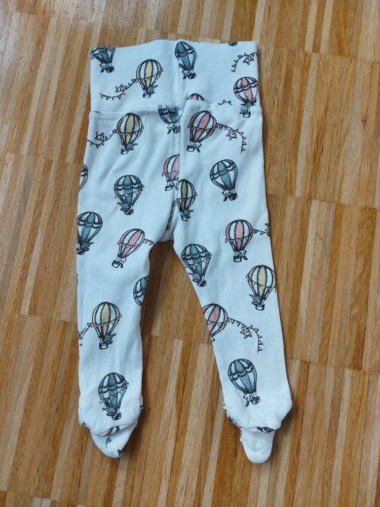 Weiße Babyhose mit breitem Bund und Füßchen und Heißluftballonmuster, Gr. 62.